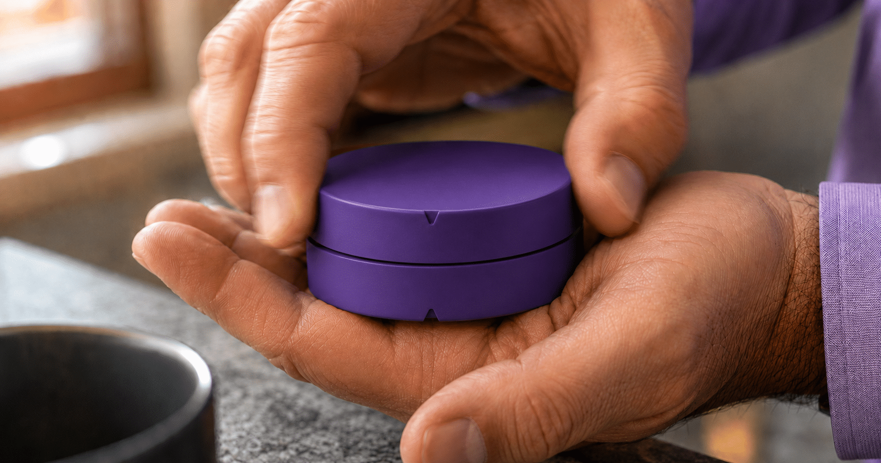 Adult hands opening a purple Secure Can Child-Resistant nicotine can with alignment arrows visible